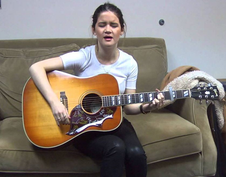 Maren Morris singing with her guitar.